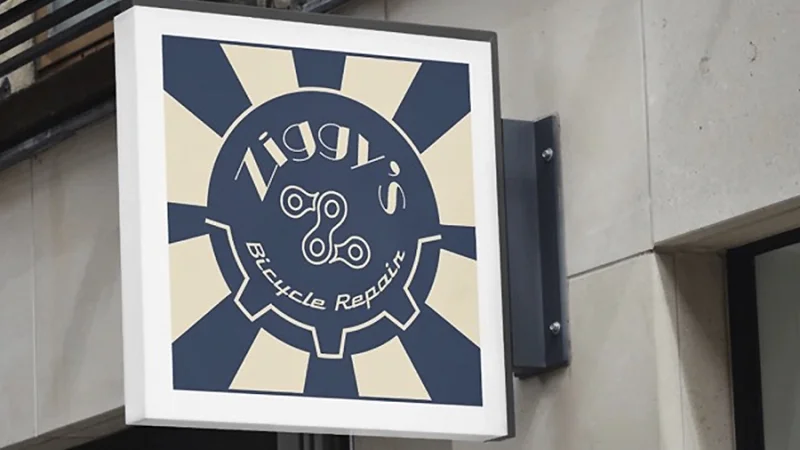 A logo that says Ziggy’s Bicycle Repair in white font against blue bicycle spokes